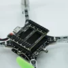 Close-up of a drone's electronic components and green propellers, focusing on the circuit board and wiring
