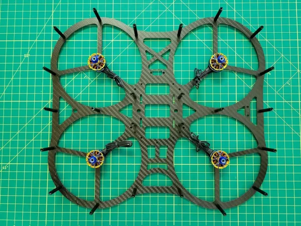 a drone frame on a green mat